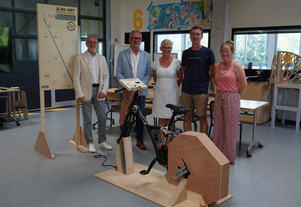 Les 5 personnes impliquées dans le projet, posant derrière le premier vélo-batterie et la borne d'information associée, dans les locaux de l'UBO Open Factory.